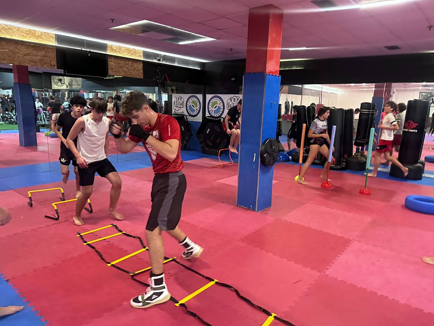 Jóvenes entrenando agilidad con escalera y vallas en la sala de ABP Sport